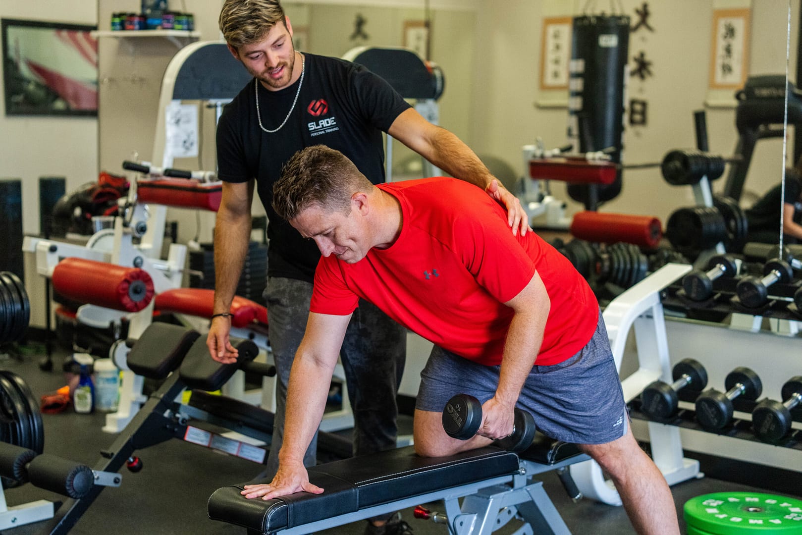 Image of a slade personal trainer advising a client in Owasso